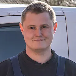 Portræt af Jesper Poulsen fra Preben Poulsen Murer & Entreprenørfirma foran en hvid servicebil.