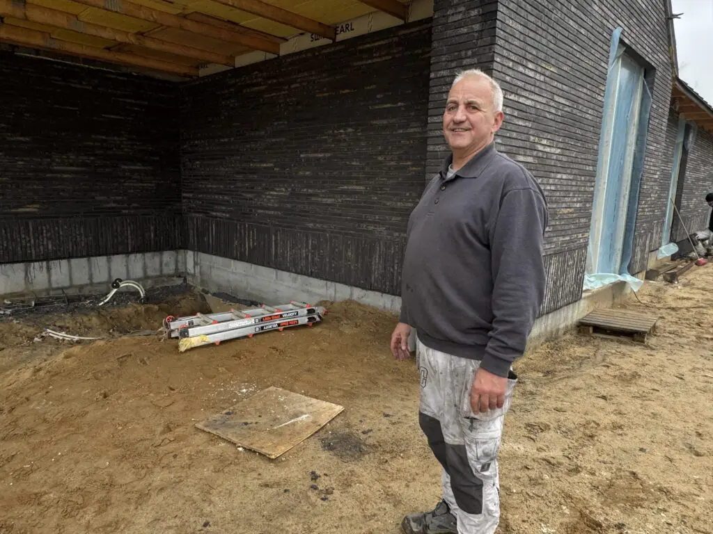 Murermester ved moderne nybyggeri med mørke mursten og lodret forbandt hos Preben Poulsen Murer & Entreprenørfirma.