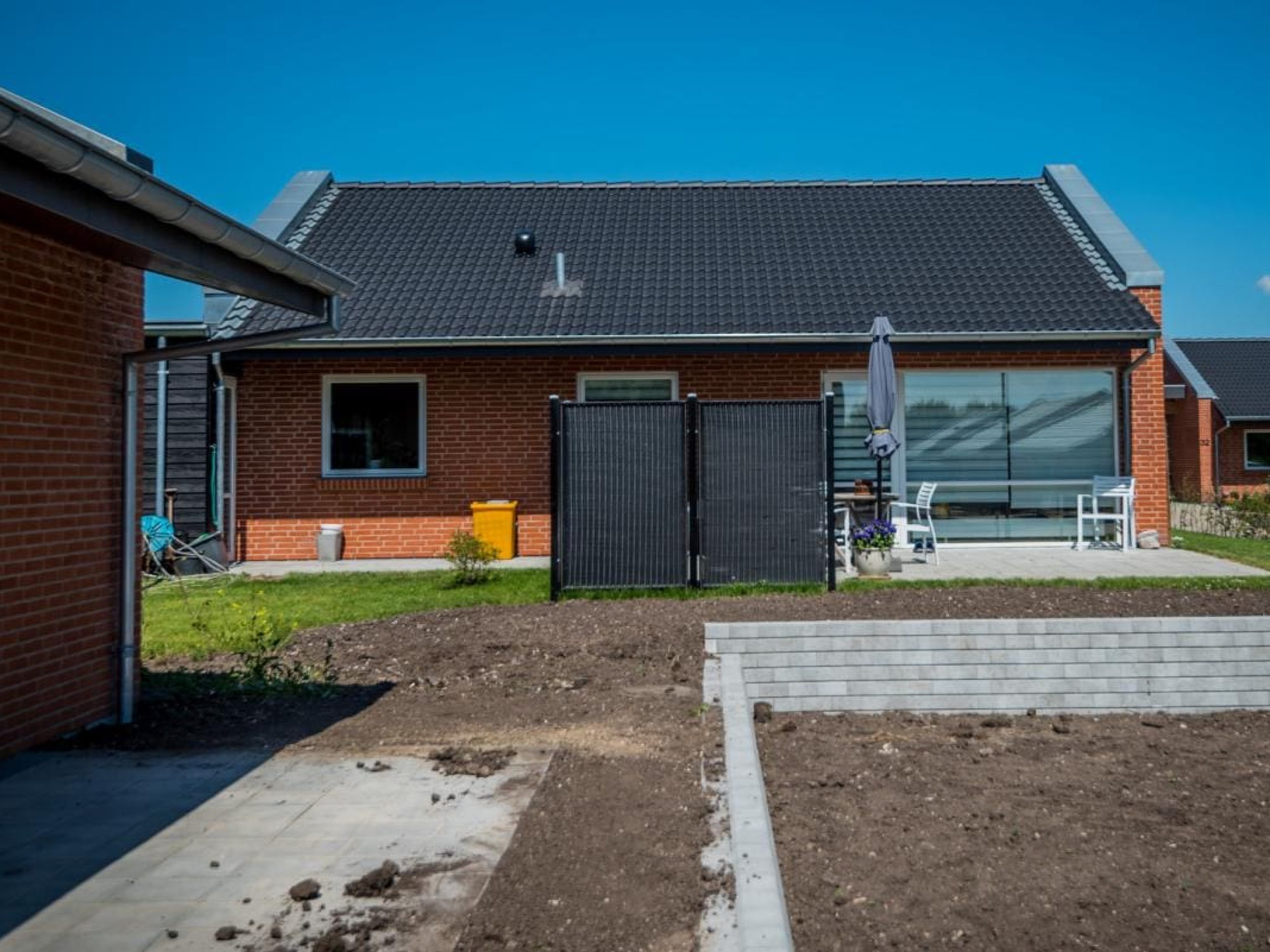 Renovering af parcelhus med murerarbejde og etablering af støttemur og udvendige anlæg udført af entreprenør.